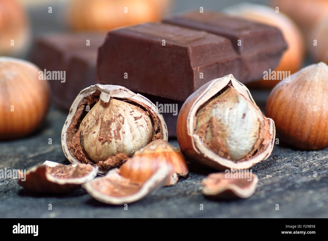 Fresh brown hazelnut on wooden table with chocolate in closeup. Selective focus. Stock Photo