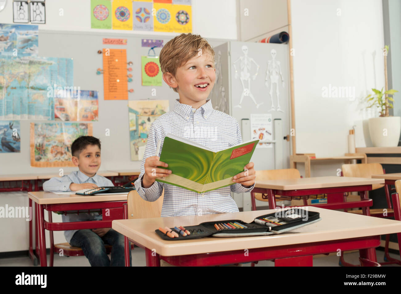 schoolboy reading a book in classroom, Munich, Bavaria, Germany Stock Photo