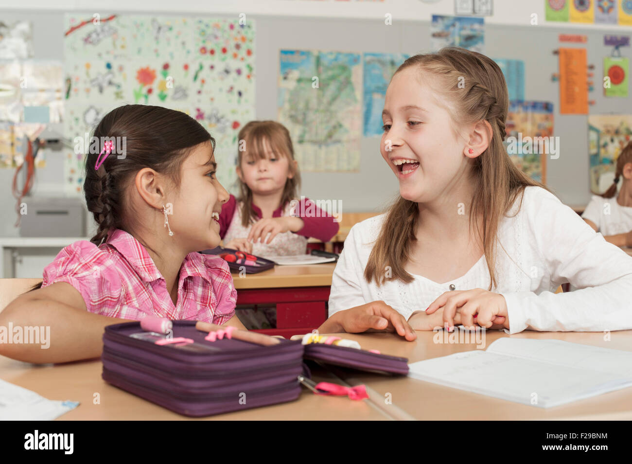 schoolgirls talking in classroom, Munich, Bavaria, Germany Stock Photo