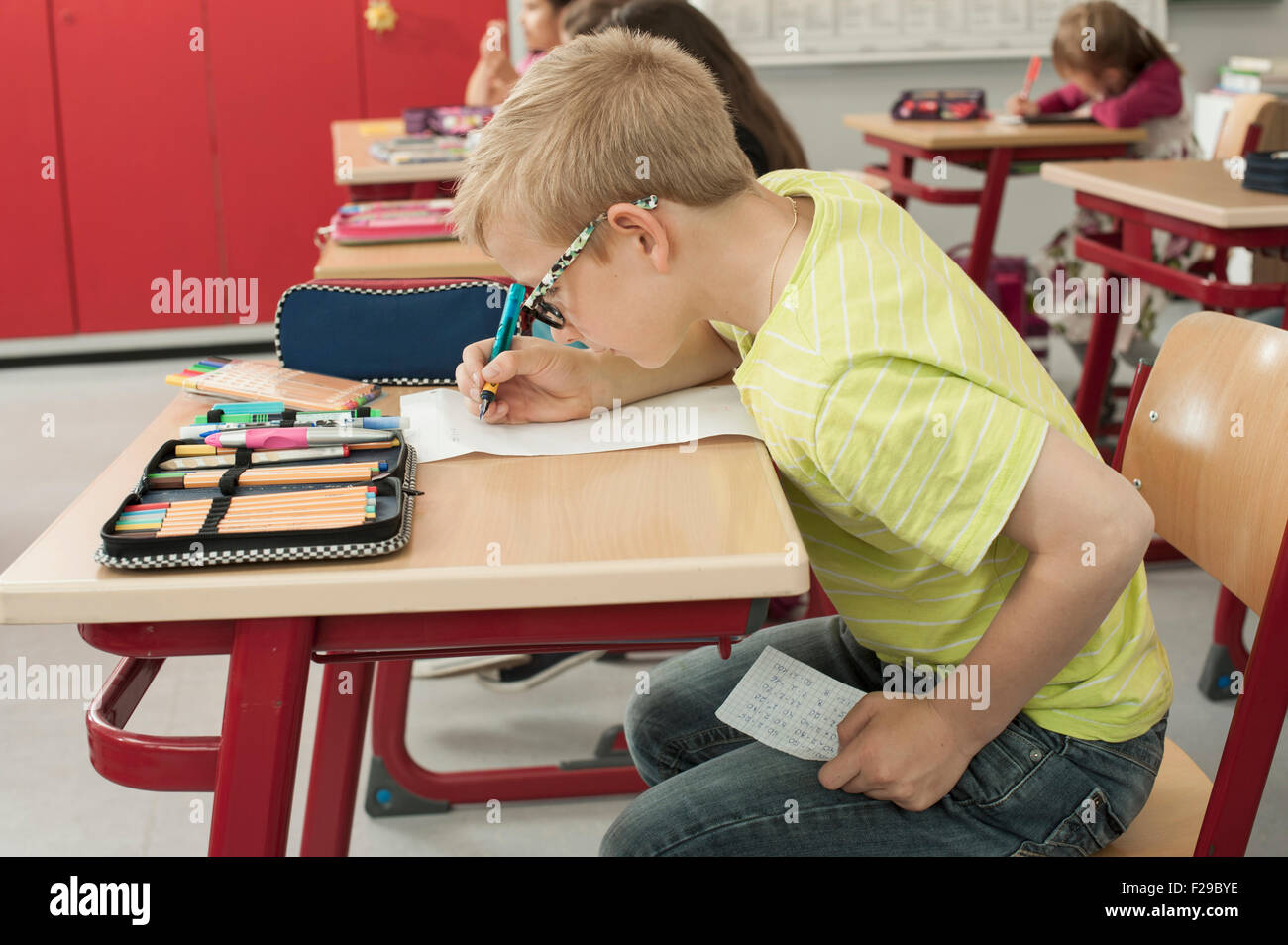 schoolboy cheating on a test in classroom, Munich, Bavaria, Germany Stock Photo