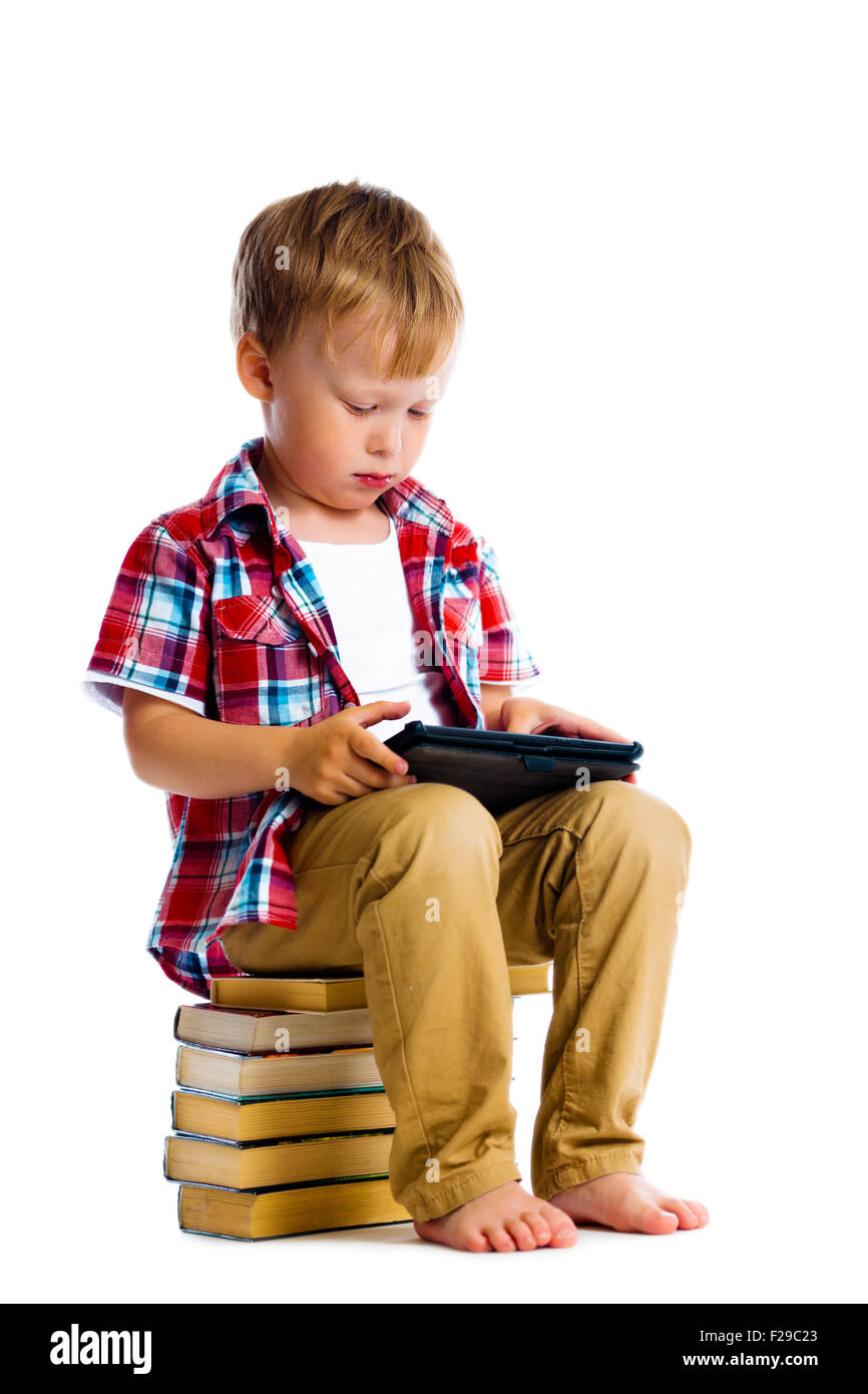 Little boy with a Tablet PC sitting on the books Stock Photo - Alamy