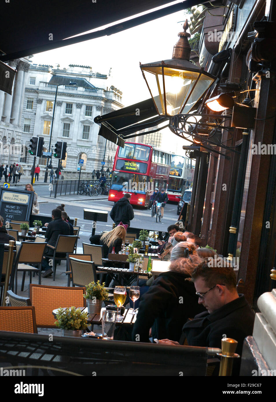 ALFRESCO DRINKING OUTDOORS AFTER WORK STREET Busy London scene at dusk with red bus commuters and typical pub in foreground The Strand London WC2 Stock Photo