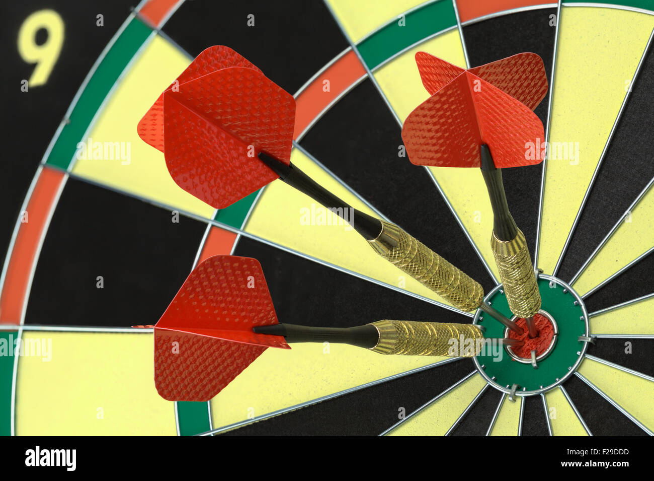 Three Darts in the Bulls Eye on Dart Board. Stock Photo