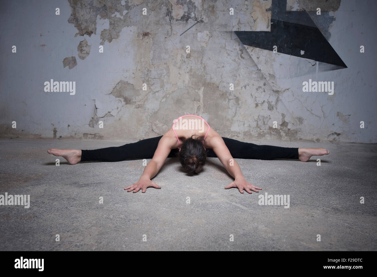 Mid adult woman practicing wide angle seated forward bend pose in yoga studio, Munich, Bavaria, Germany Stock Photo
