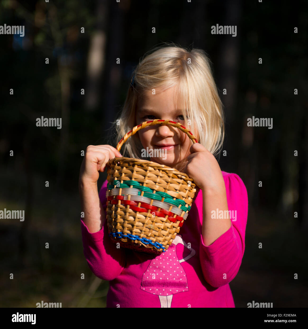 Cute little girl with wicker basket posing and walking through the