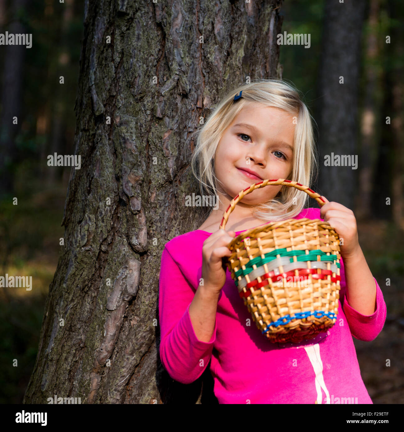 Cute little girl with wicker basket posing and walking through the