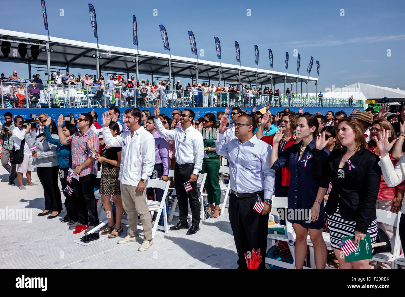 Miami Beach Florida,Oath of Citizenship Ceremony,immigrants,naturalization,citizen,swearing in,new citizens,allegiance,hands raised,Hispanic man men m Stock Photo