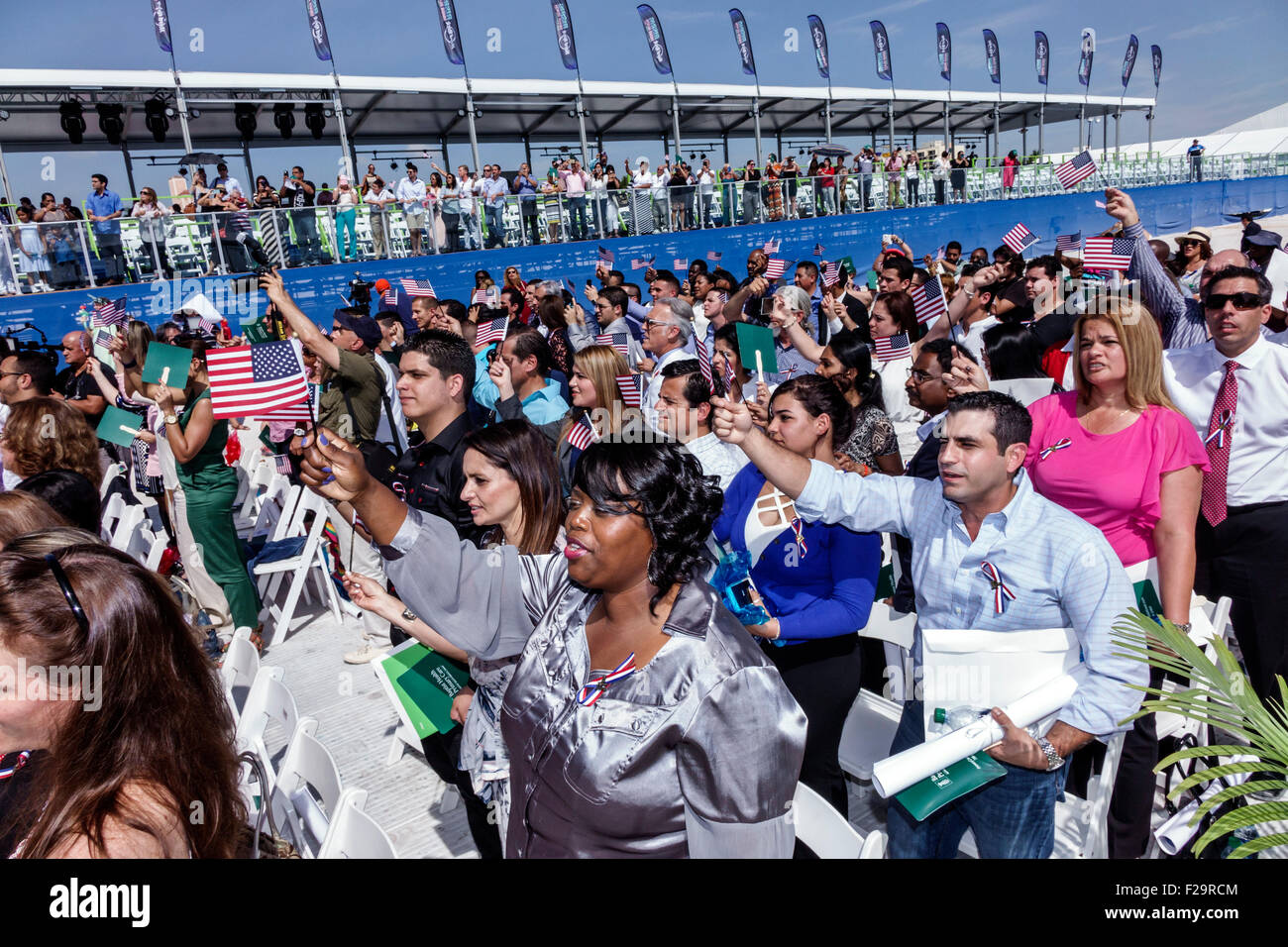 Miami Beach Florida,Oath of Citizenship Ceremony,immigrants,naturalization,citizen,swearing in,new citizens,allegiance,waving flags,Black Blacks Afric Stock Photo