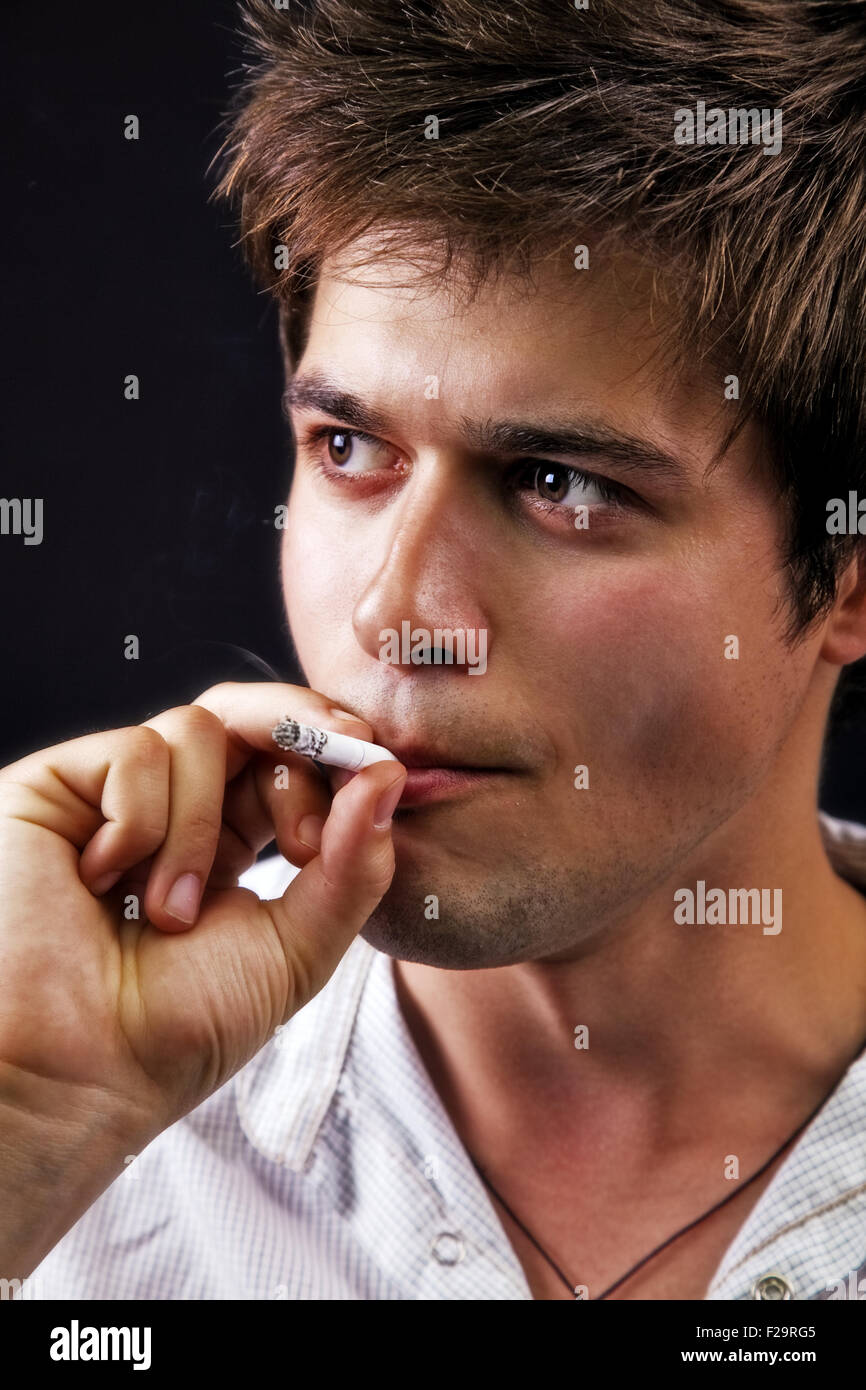 One young sexy man smoking a cigarette Stock Photo - Alamy