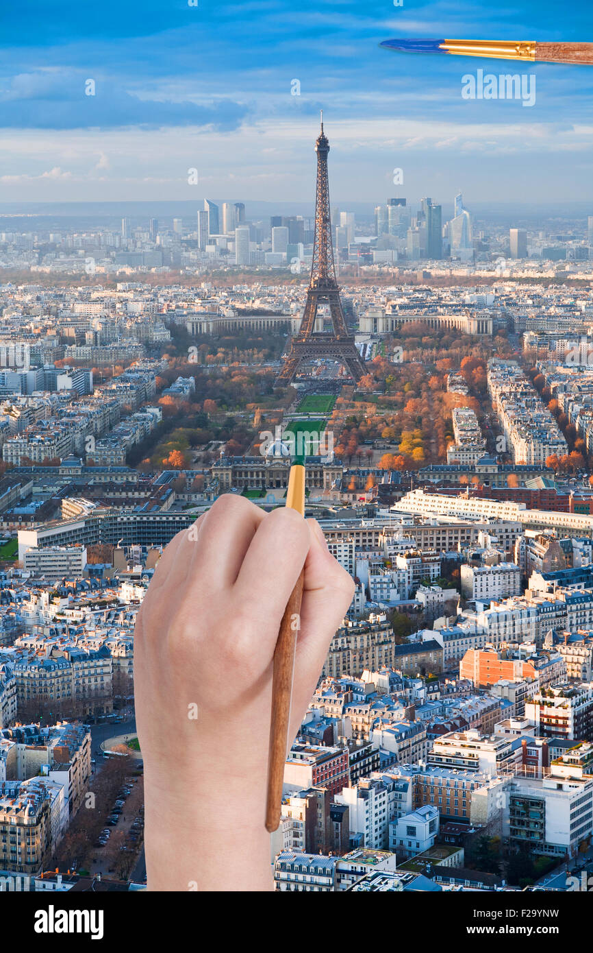 travel concept - hand with paintbrush paints in green colour Champ de Mars near Eiffel tower in Paris city, France Stock Photo