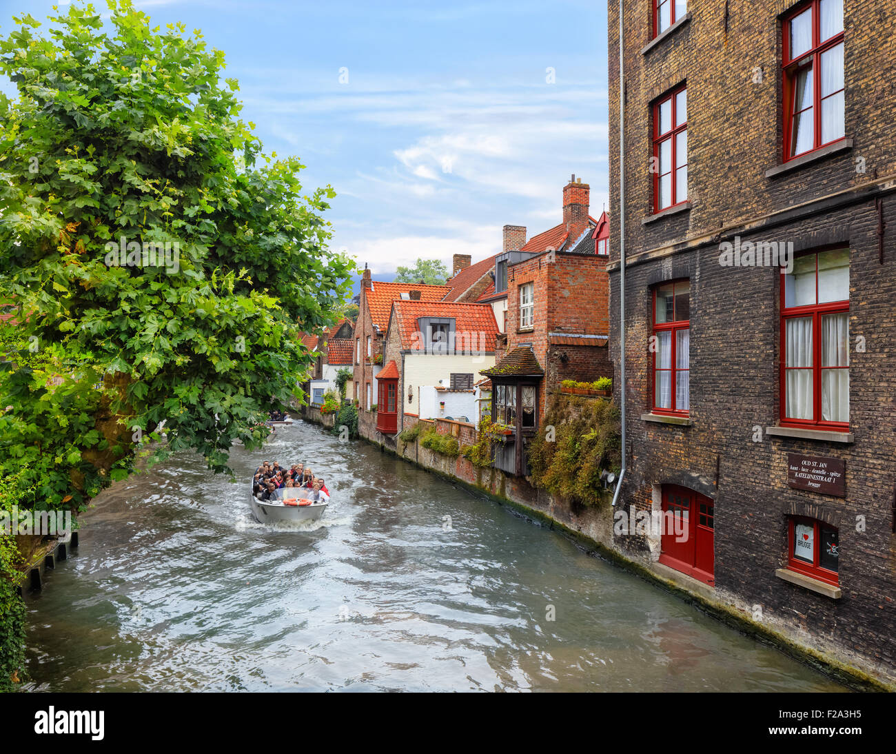 Bruges, Belgium - Aug 18, 2015: Tourists taking boat tour around medieval canals Stock Photo