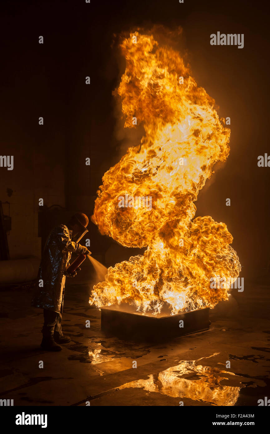 Firefighter extinguishes a heptane 5B pan fire with a 2-BTP extinguisher, Illinois, Chicago, USA Stock Photo