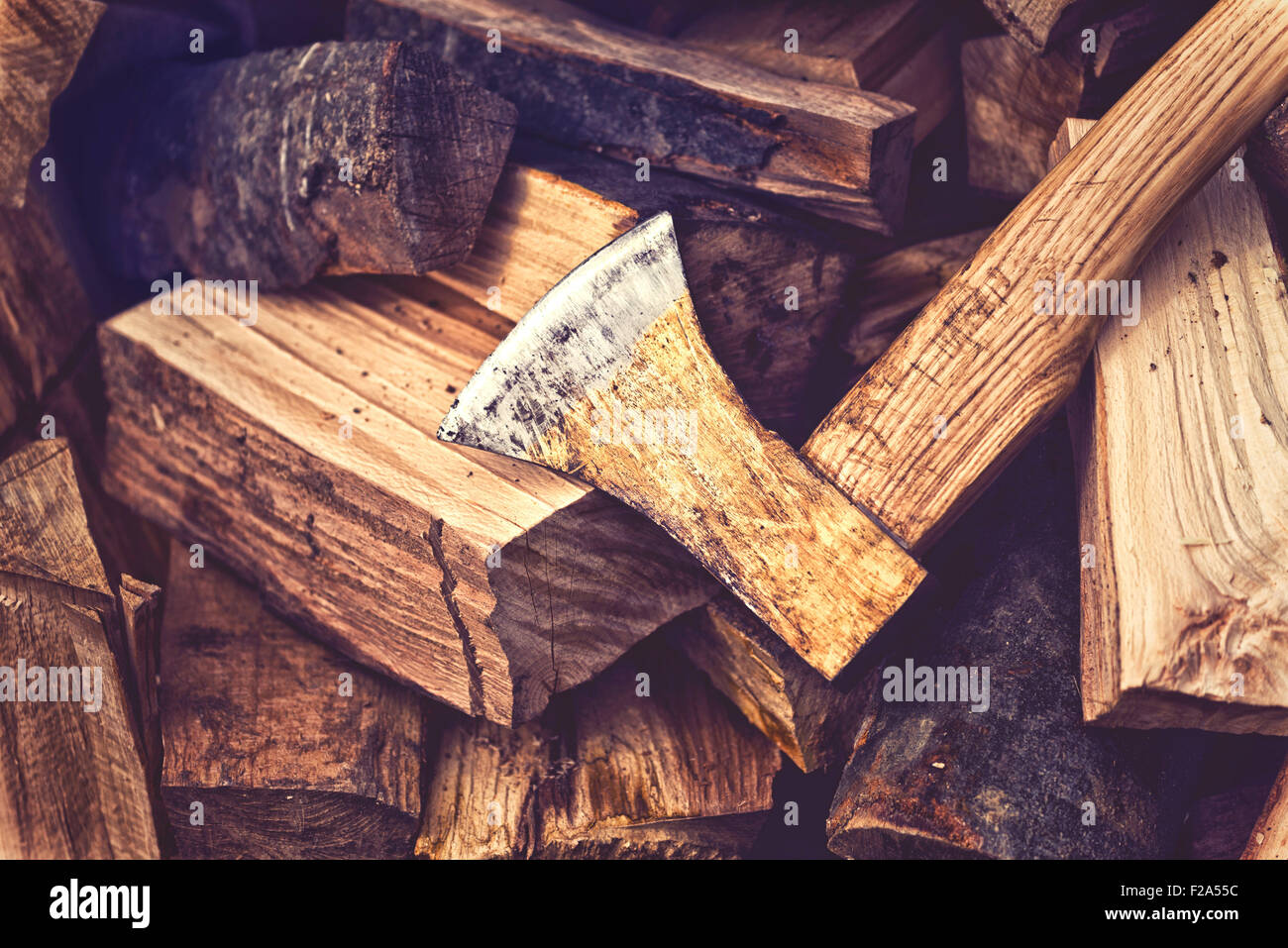 Hatchet Ax and Pile of Split Wood Logs for Fire, Selective Focus with Shallow Depth of Field, Toned Image. Stock Photo