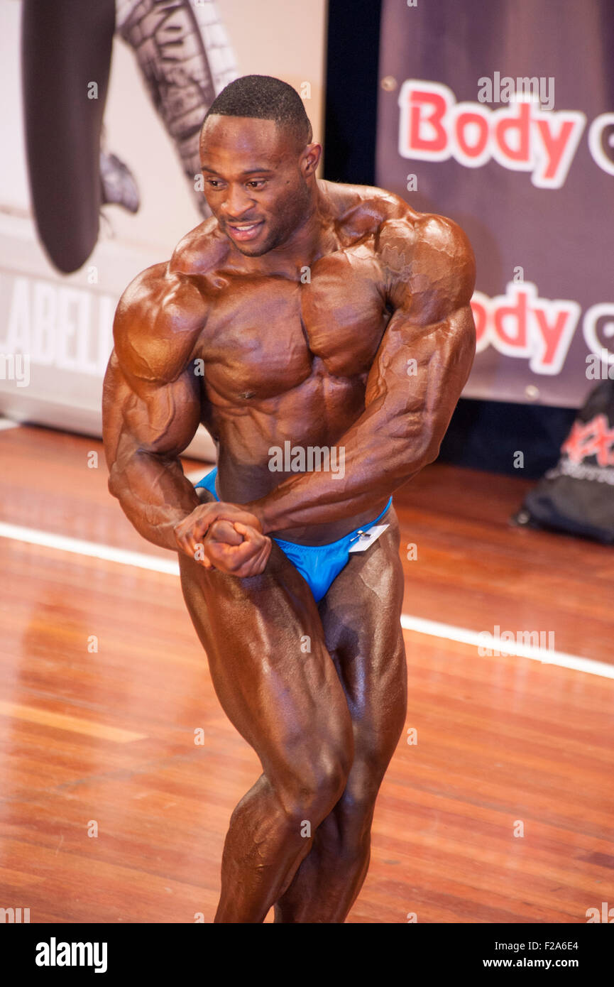 SCHIEDAM, THE NETHERLANDS - APRIL 26, 2015. Male bodybuilder Michael Muzo shows his best chest pose on stage Stock Photo
