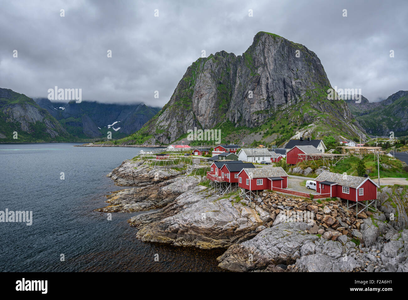 Traditional red rorbu cottages under the  Lilandstinden mountain peak in Hamnoy village, Lofoten islands, Norway. Stock Photo