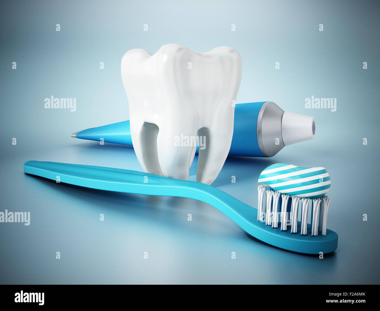 Tooth, toothpaste and toothbrush on blue surface Stock Photo