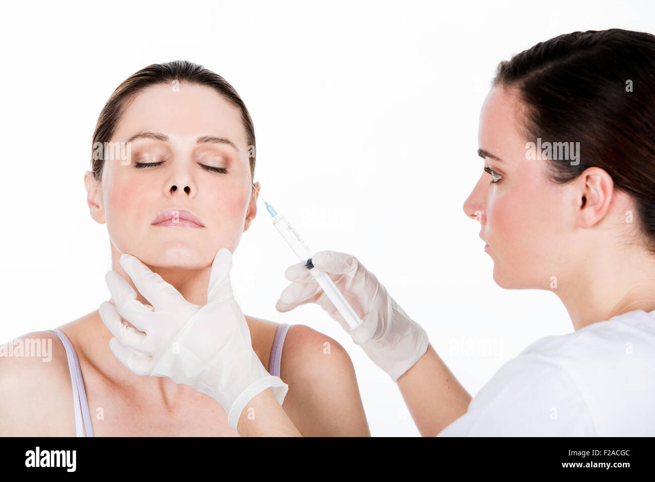 doctor gets botox injection to a woman patient Stock Photo