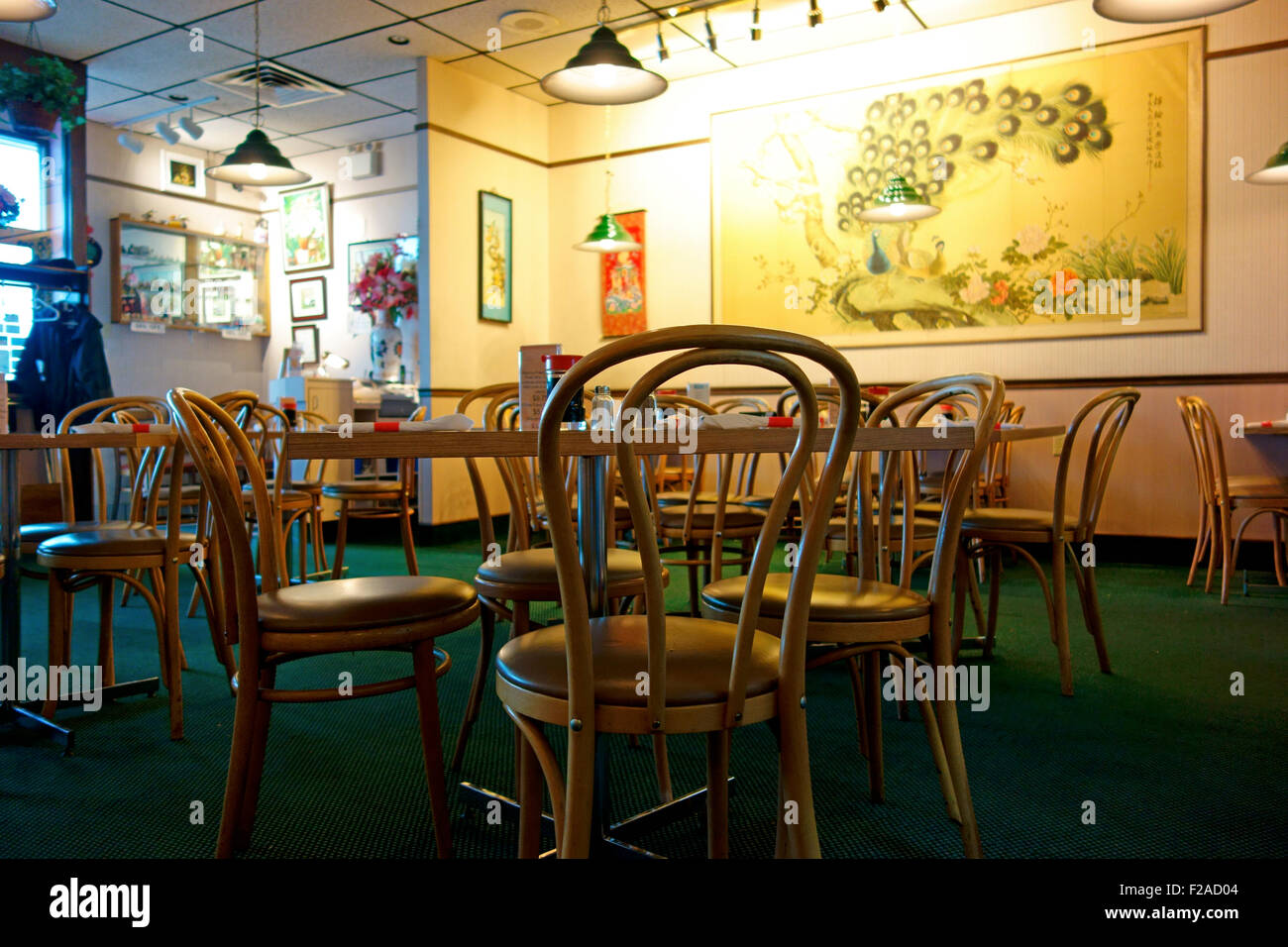 The interior of a Chinese Restaurant showing tables, chairs and wall hangings Stock Photo