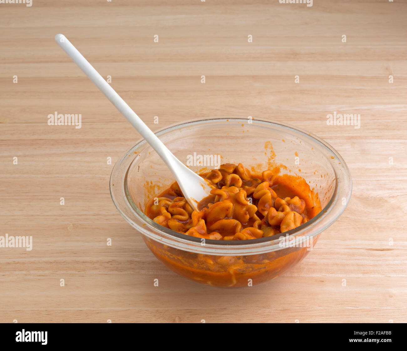 A large serving bowl with a heated can of pasta lasagna with a spoon on