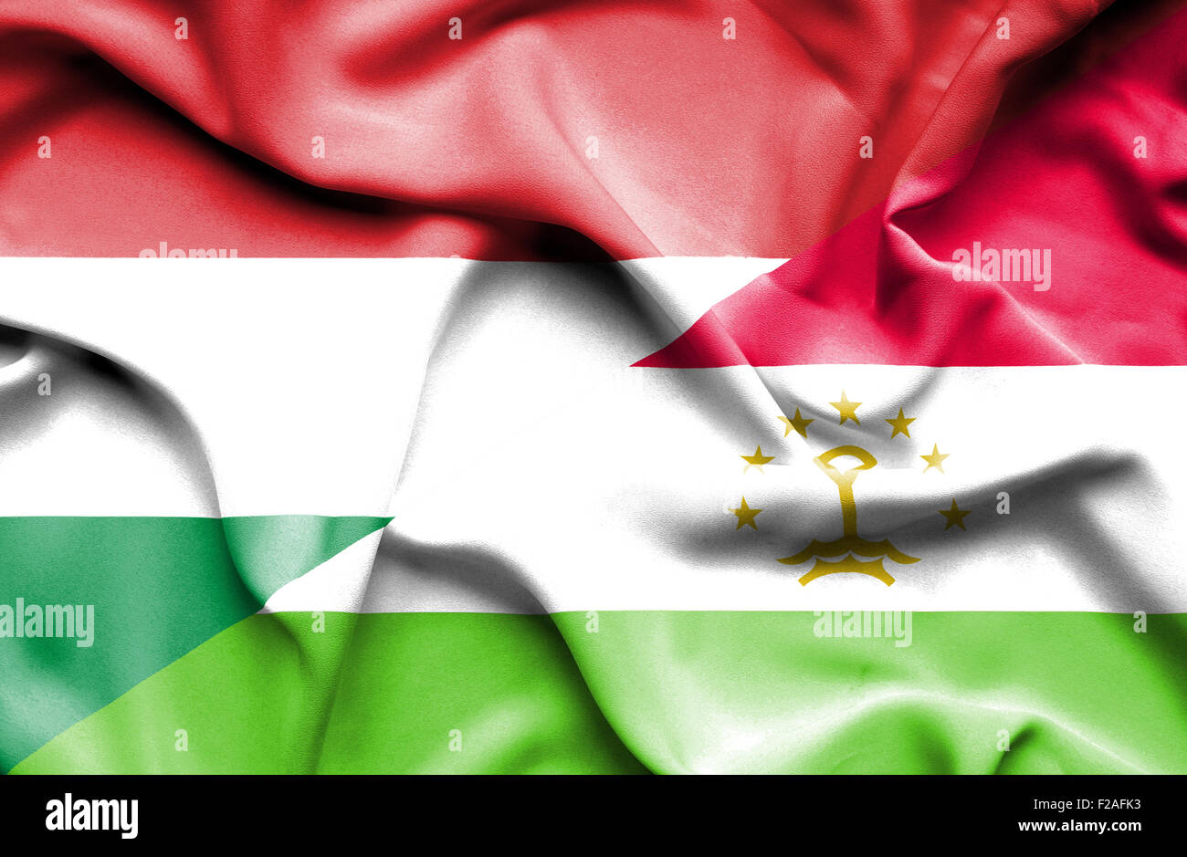 Waving flag of Tajikistan and Hungary Stock Photo
