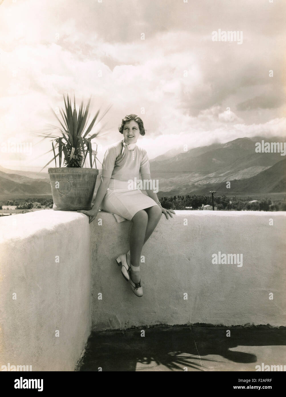 Woman sitting on outdoor ledge (OLVI008 OU331 F) Stock Photo