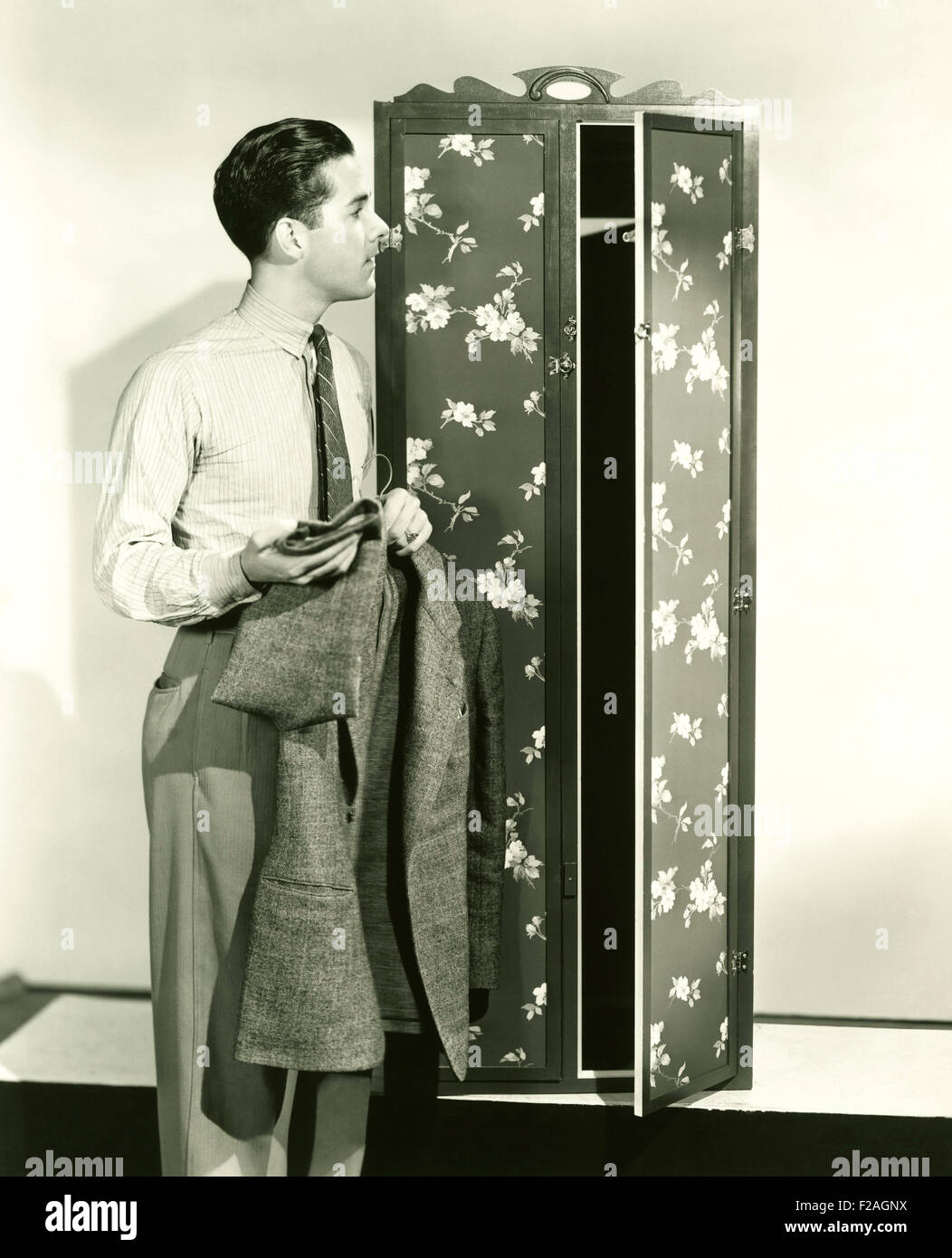 Man hanging up blazer in armoire (OLVI008 OU082 F) Stock Photo