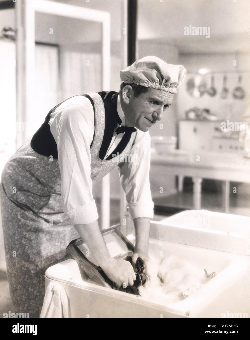 Man washing clothes in the kitchen sink (OLVI008 OU054 F) Stock Photo