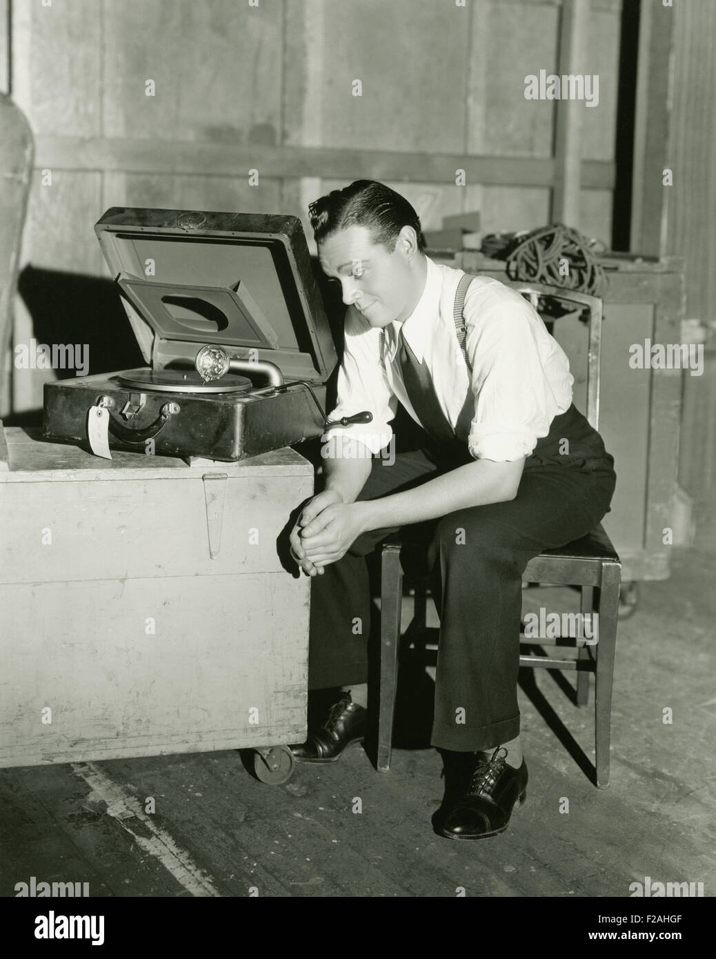 Man listening to portable gramophone (OLVI007 OU935 F) Stock Photo