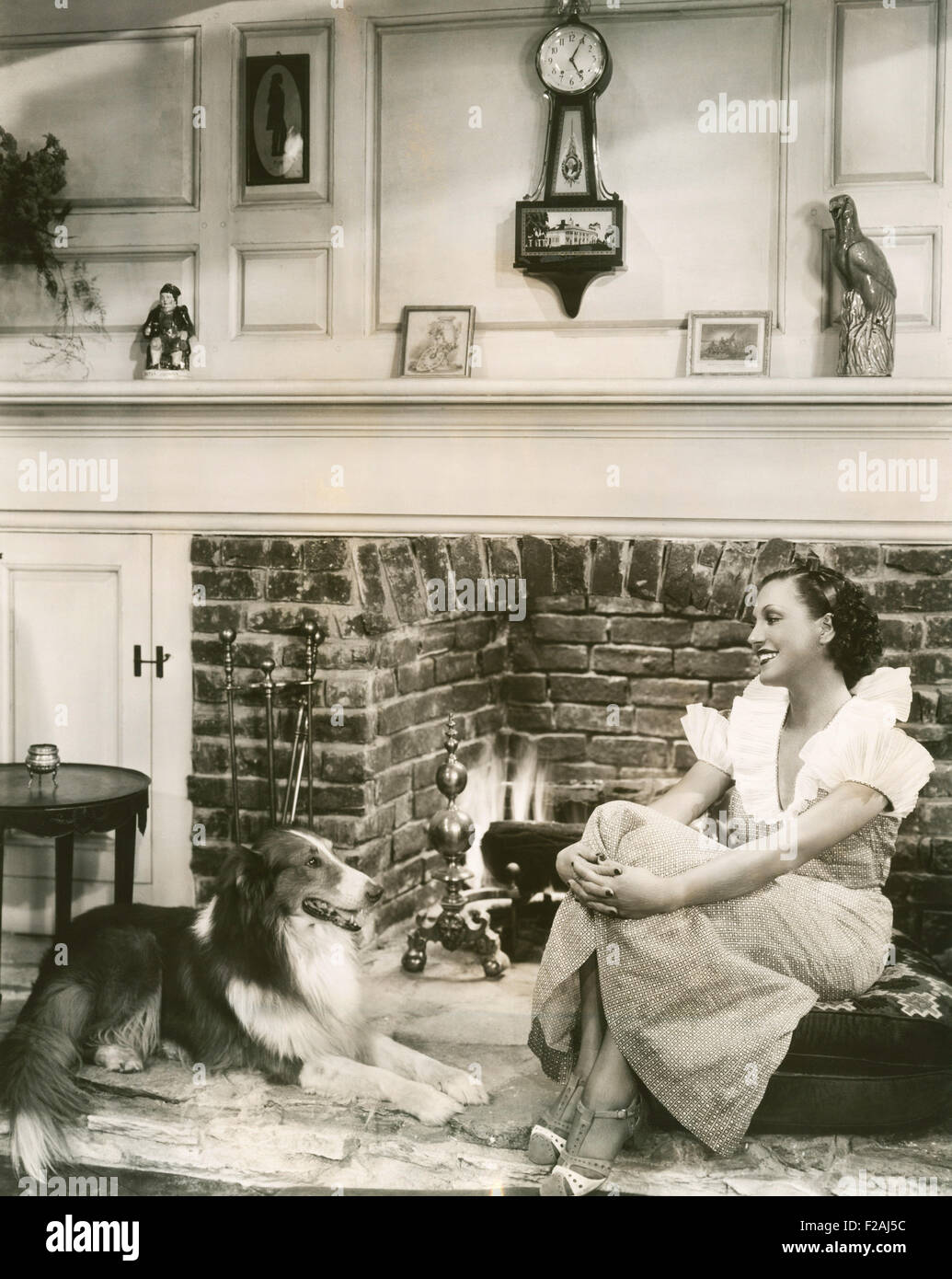 Relaxing in front of the fireplace with her collie (OLVI007 OU827 F) Stock Photo