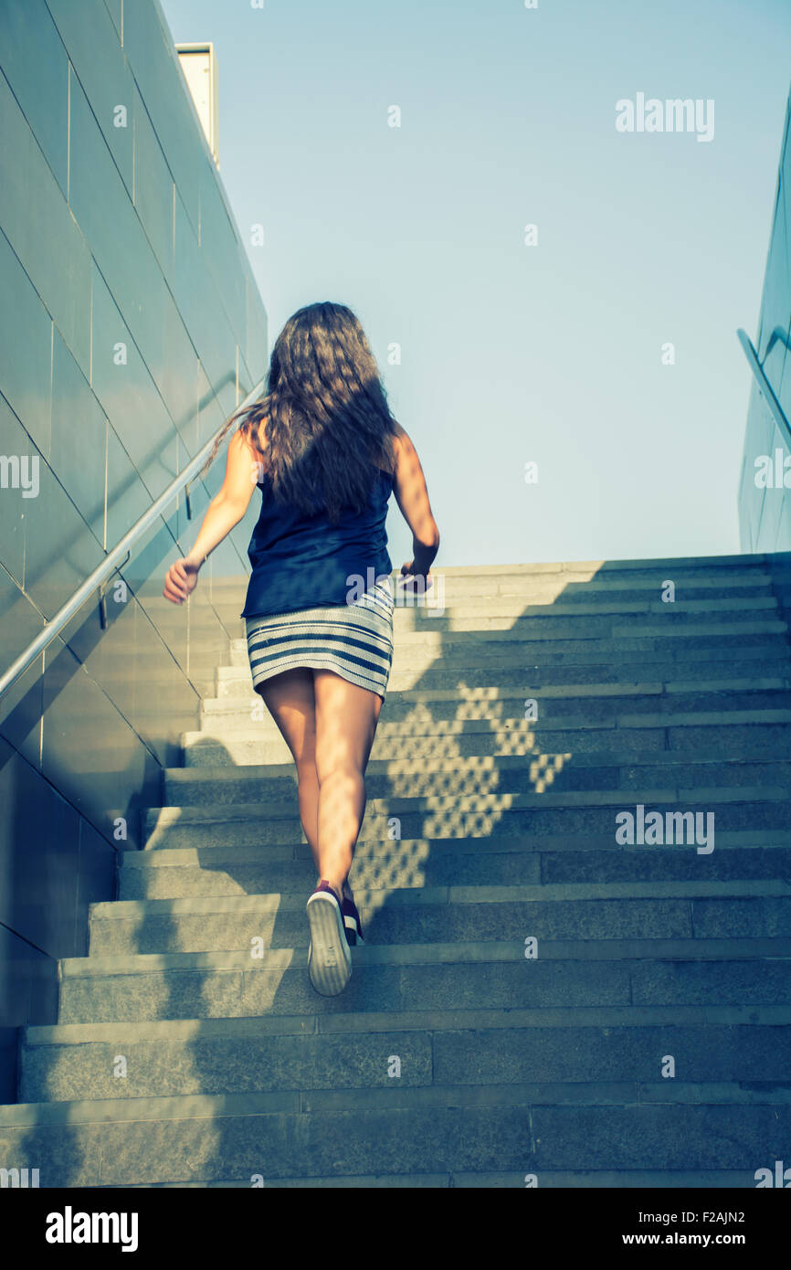 Young woman walking up the stairs Stock Photo