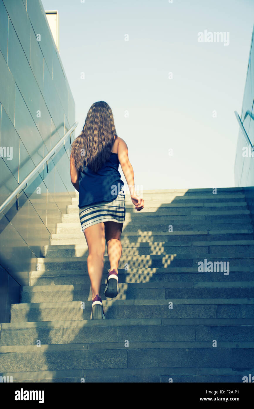 Young woman walking up the stairs Stock Photo