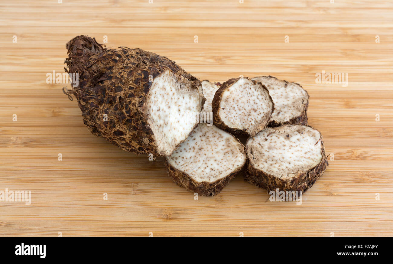 A freshly cut Malanga on a wood cutting board illuminated with natural light. Stock Photo