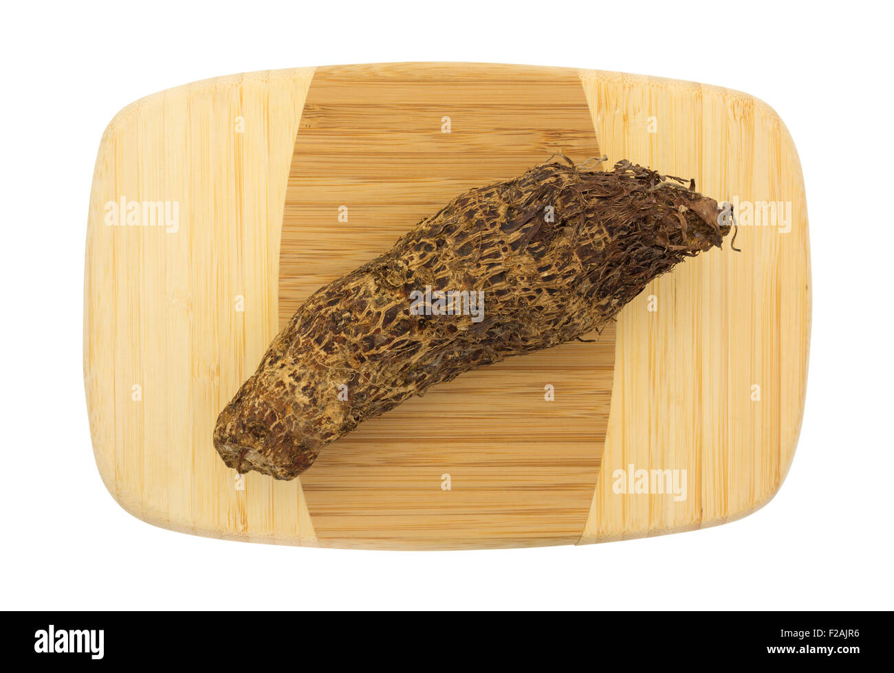 Top view of a fresh Malanga on a small wood cutting board isolated on a white background. Stock Photo