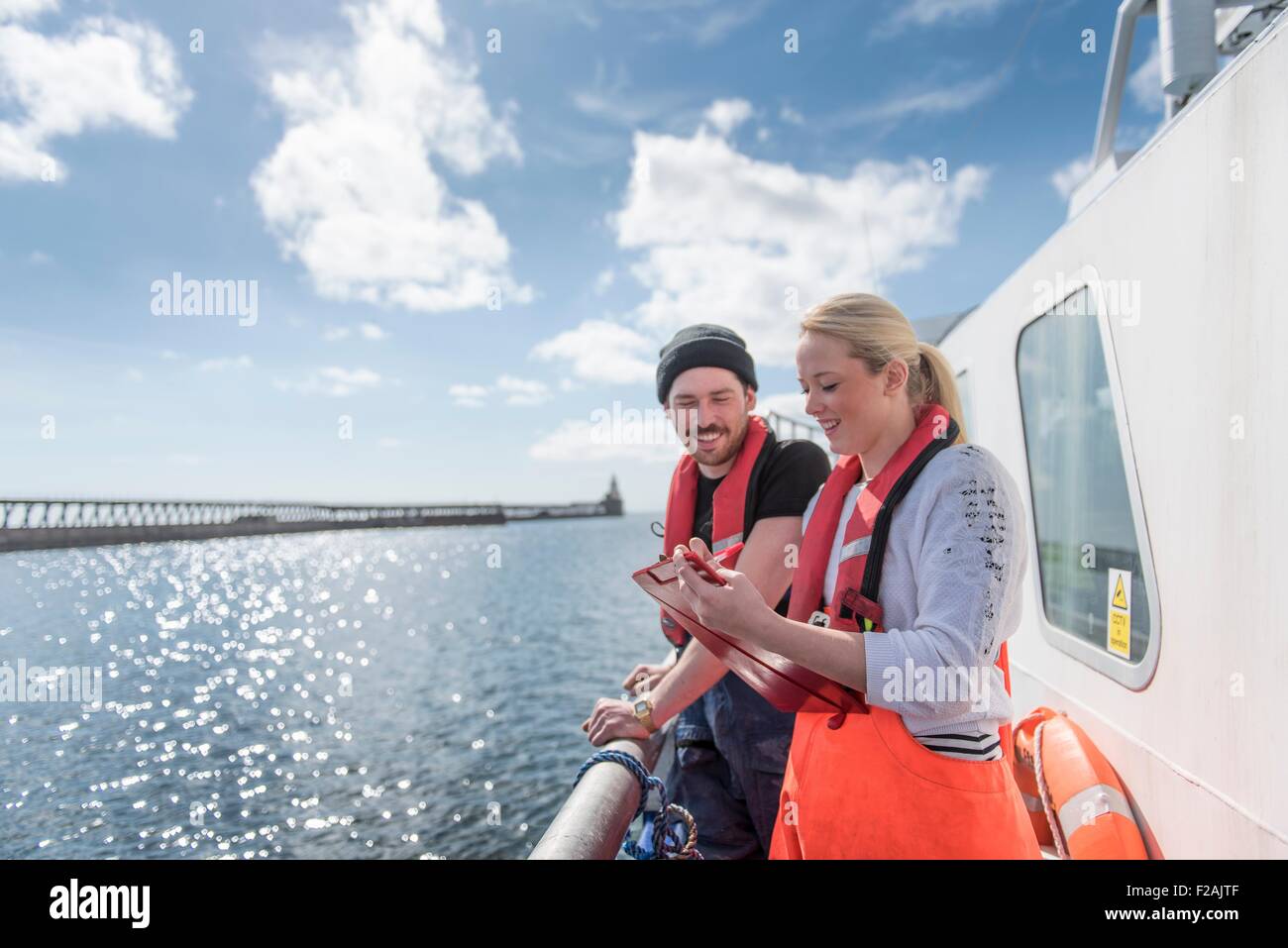 Research scientists looking at wildlife on research ship Stock Photo
