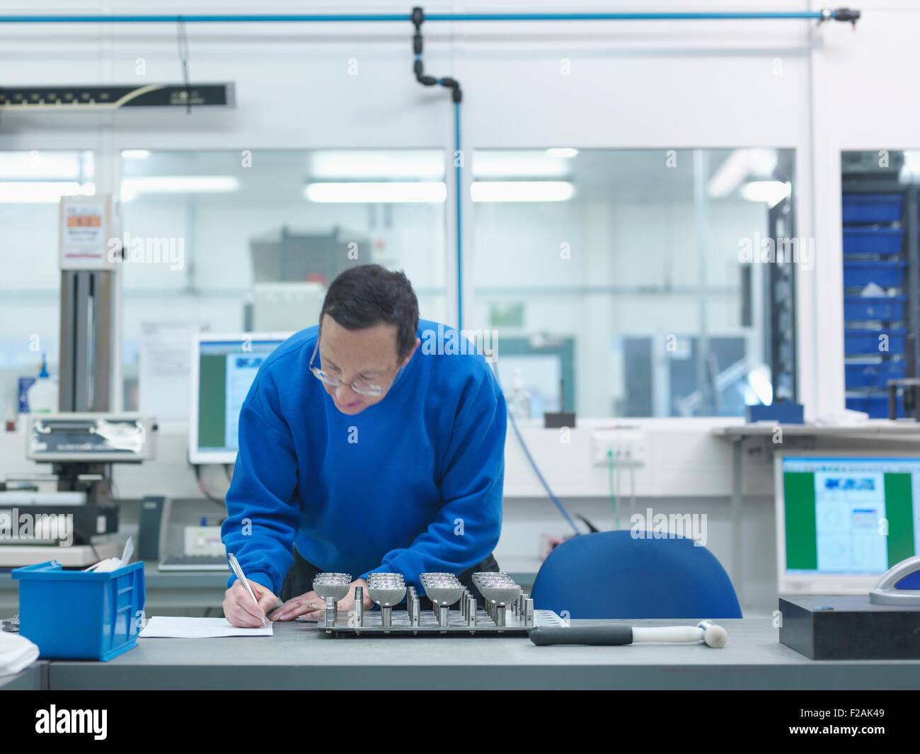 Engineer inspecting artificial hip joint parts in quality control department in orthopaedic factory Stock Photo