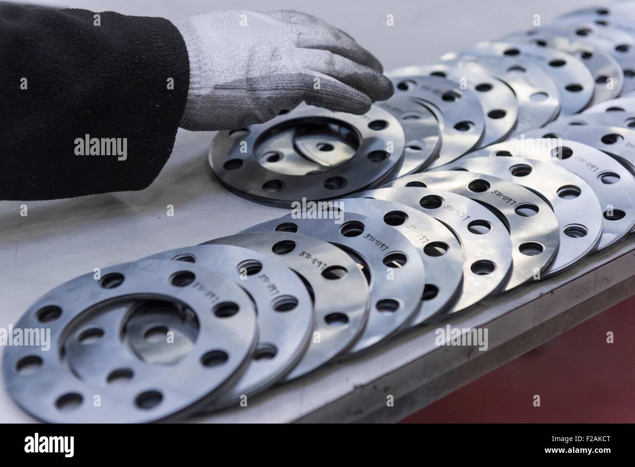 Engineers hand arranging cut parts in engineering factory, close up Stock Photo