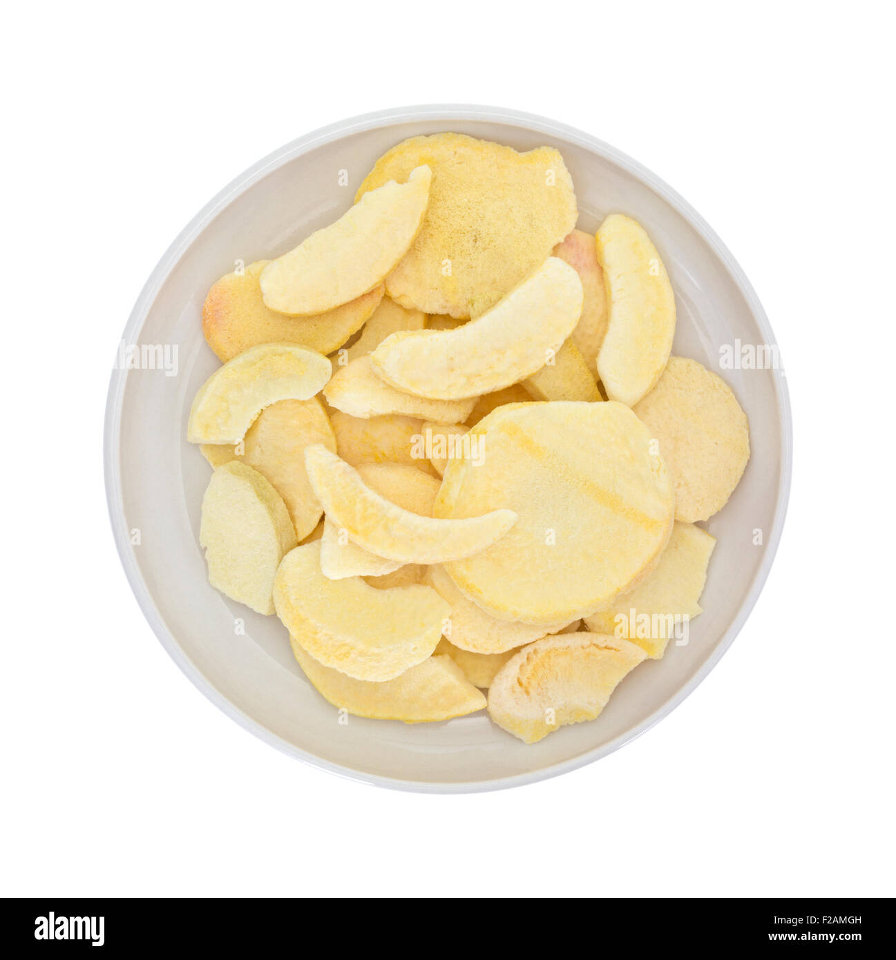Top view of a plate of dried peach slices isolated on a white