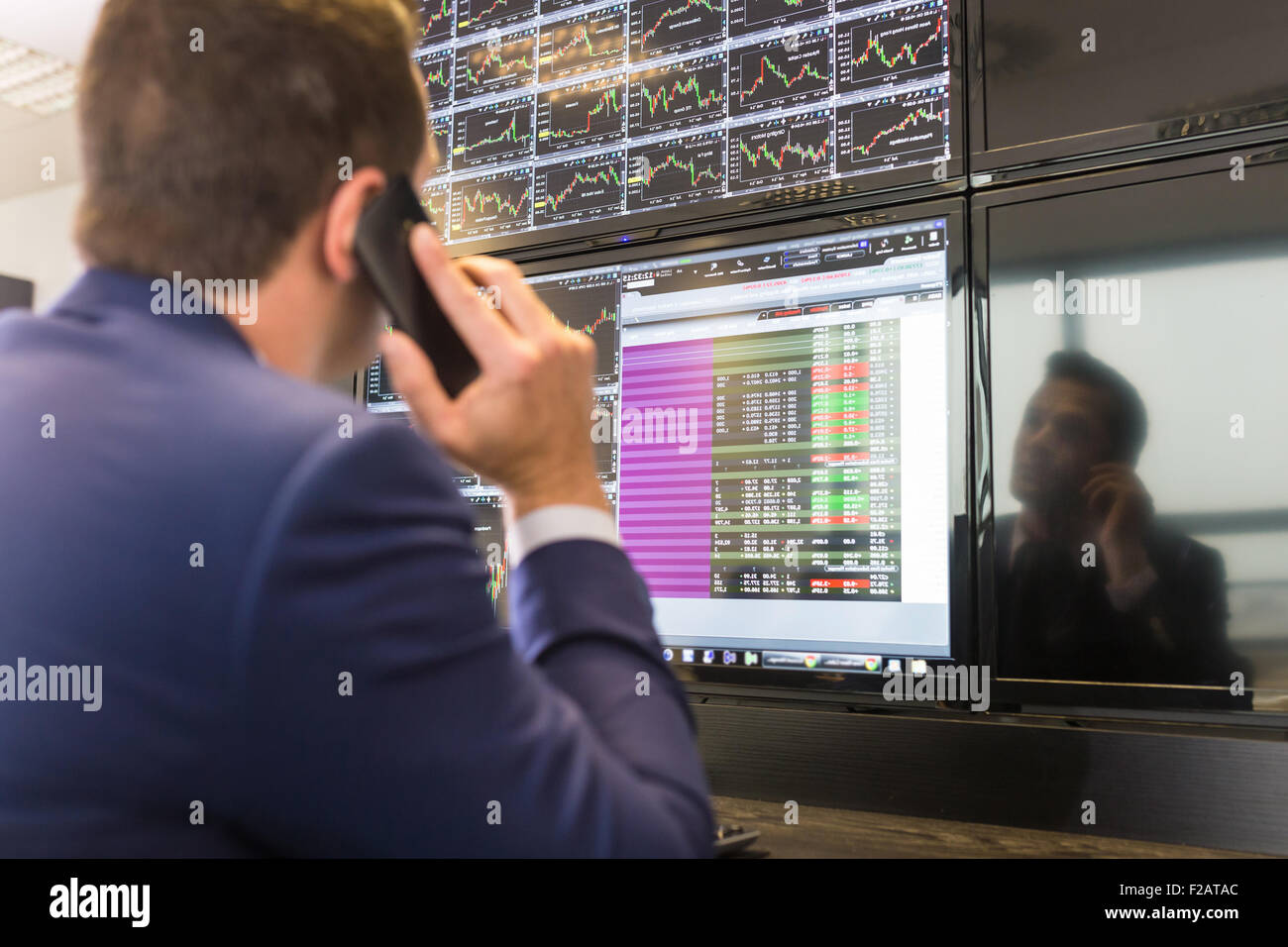 Stock trader looking at computer screens. Stock Photo