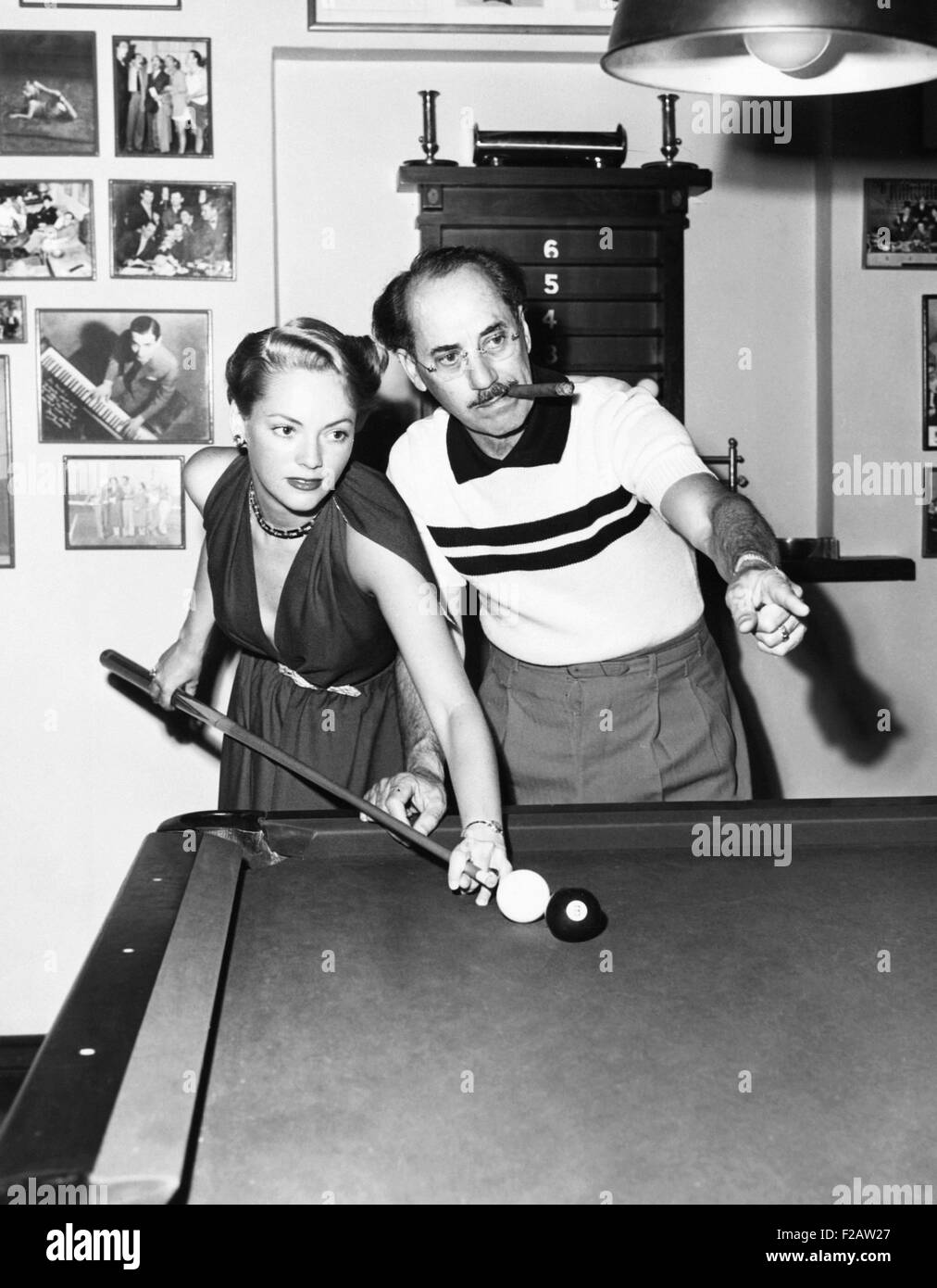 Groucho Marx at home playing billiards with his young wife, Actress Kay Maris in 1949. Her first husband was Actor Leo Gorcey, whom she married when she was 17. (CSU 2015 11 1481) Stock Photo