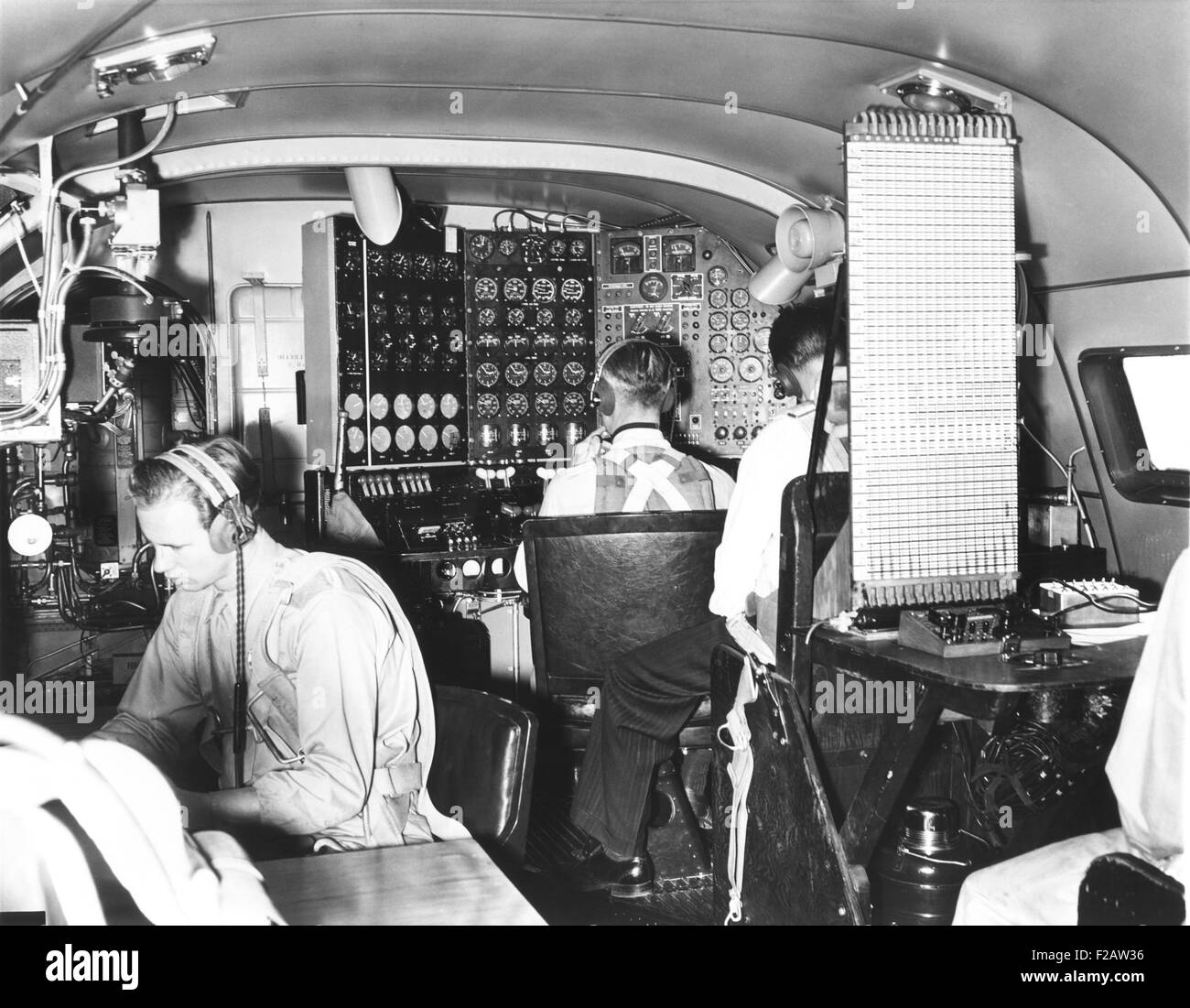 In the cabin of the 82-ton Douglas B-19, the world's largest bomber. Nov. 13, 1941. L-R: the radioman, the flight engineer at the complex 'dashboard,' and a representative from the Wright Duplex – Cyclone Motor Company. The flying battleship was powered by four 2000 horse power Wright Duplex Cyclone engines. (CSU 2015 11 1456) Stock Photo