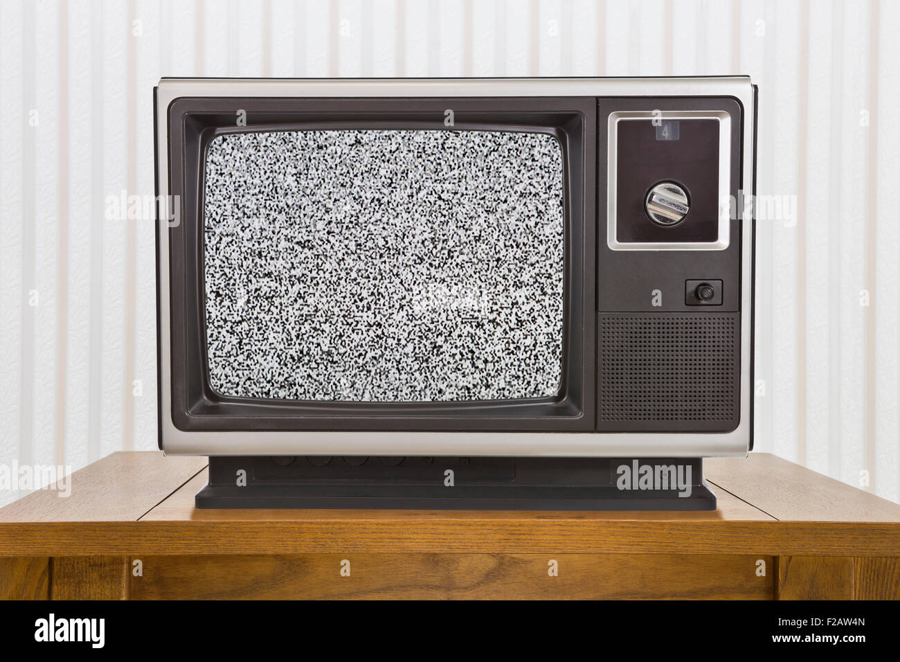 Old analogue portable television on table with static screen. Stock Photo