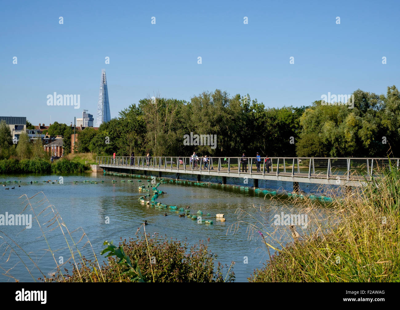 10 September 2015: Walworth, South London: The lake, Burgess Park boardwalk with The Shard and the city of London Stock Photo