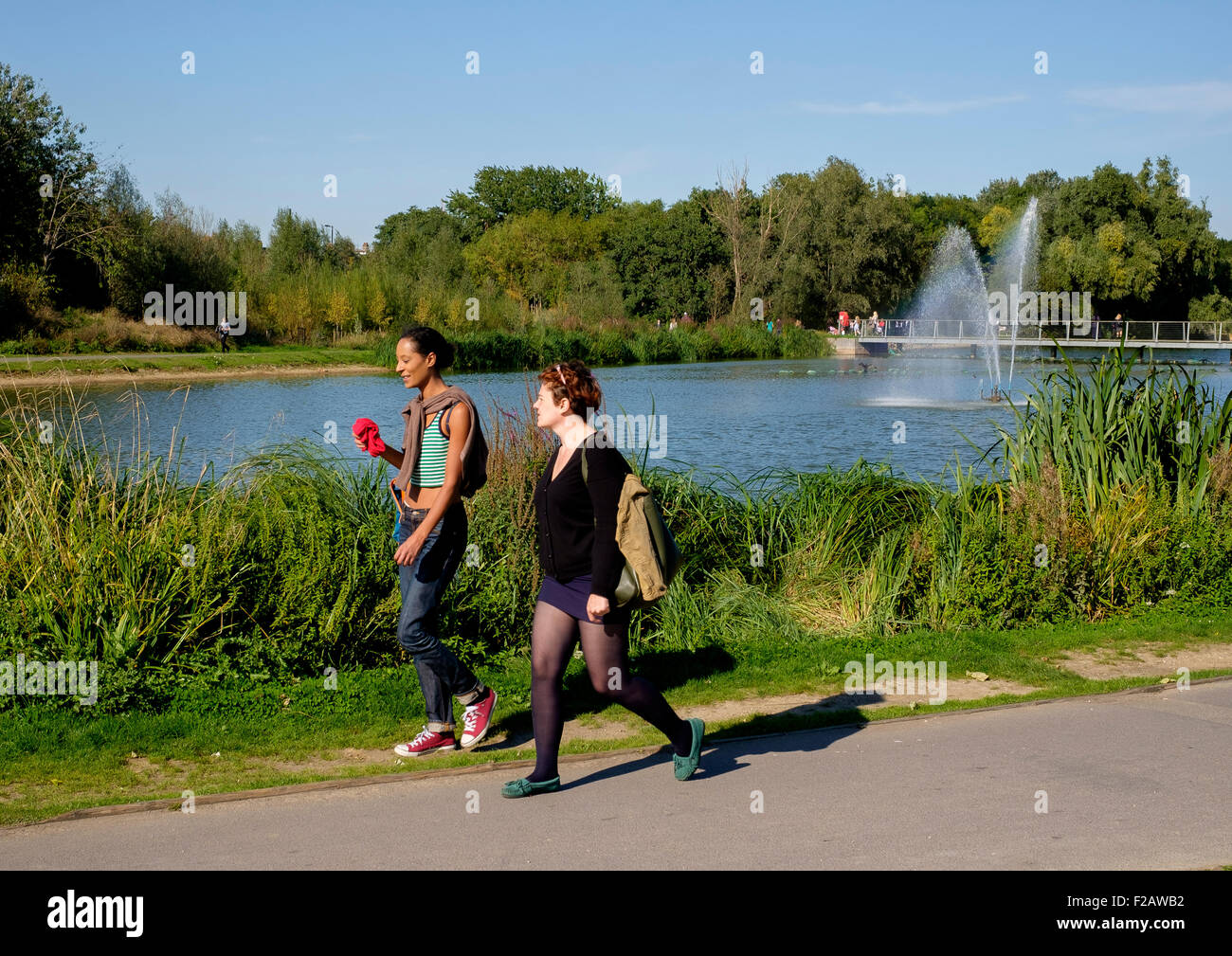10 September 2015: Walworth, South London: Two women on a afternoon walk by the lake, Burgess Park Stock Photo