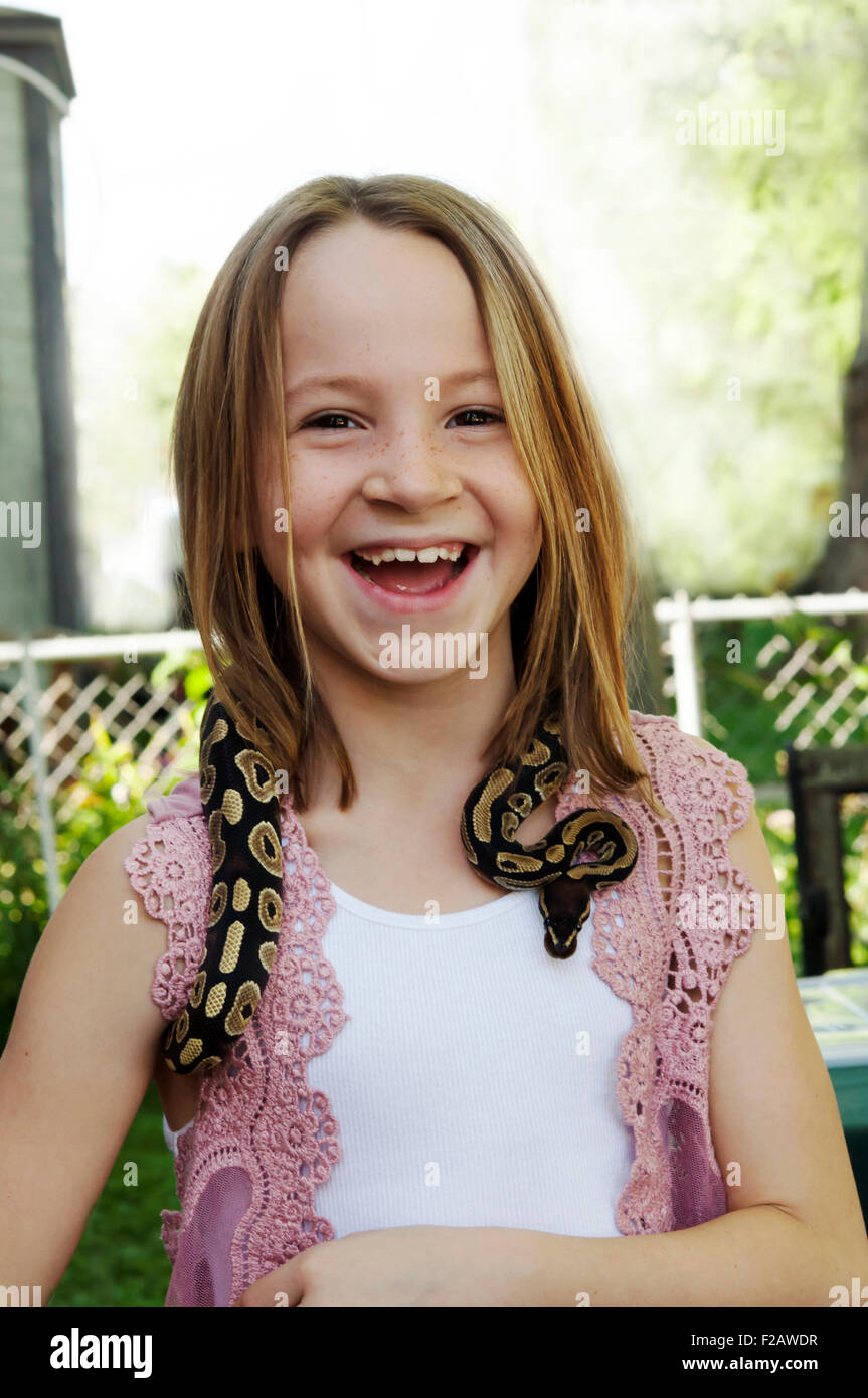Young girl with boa constrictor around neck Stock Photo