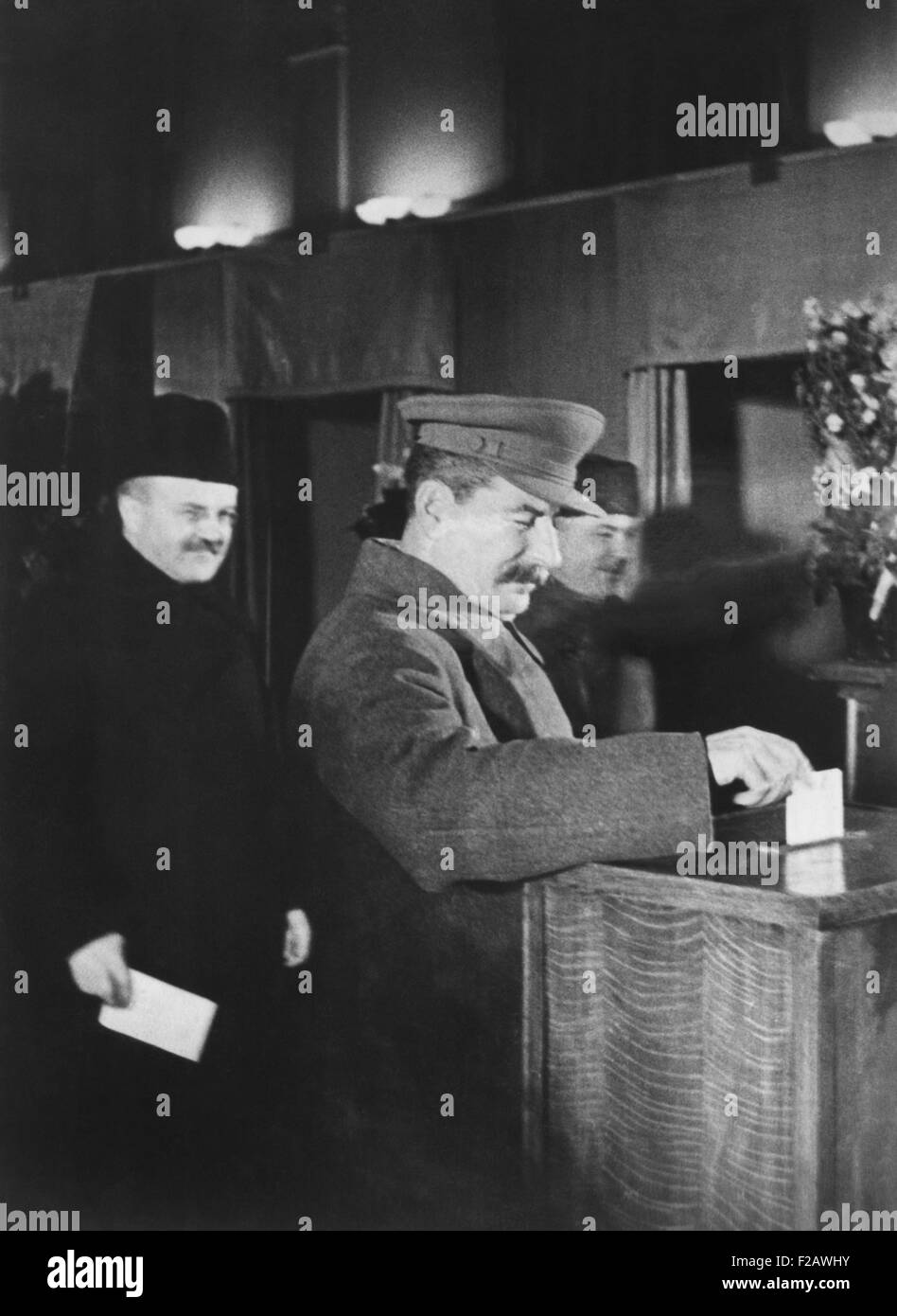 Josef Stalin, voting at an election for members of the Supreme Soviet. Ca. 1940. Behind Stalin is V. Molotov (left), Chairman of the Council of People's Commissars and Commissar of Foreign Affairs, and K. Voroshilov, Commissar for Defense. (CSU 2015 11 1363) Stock Photo