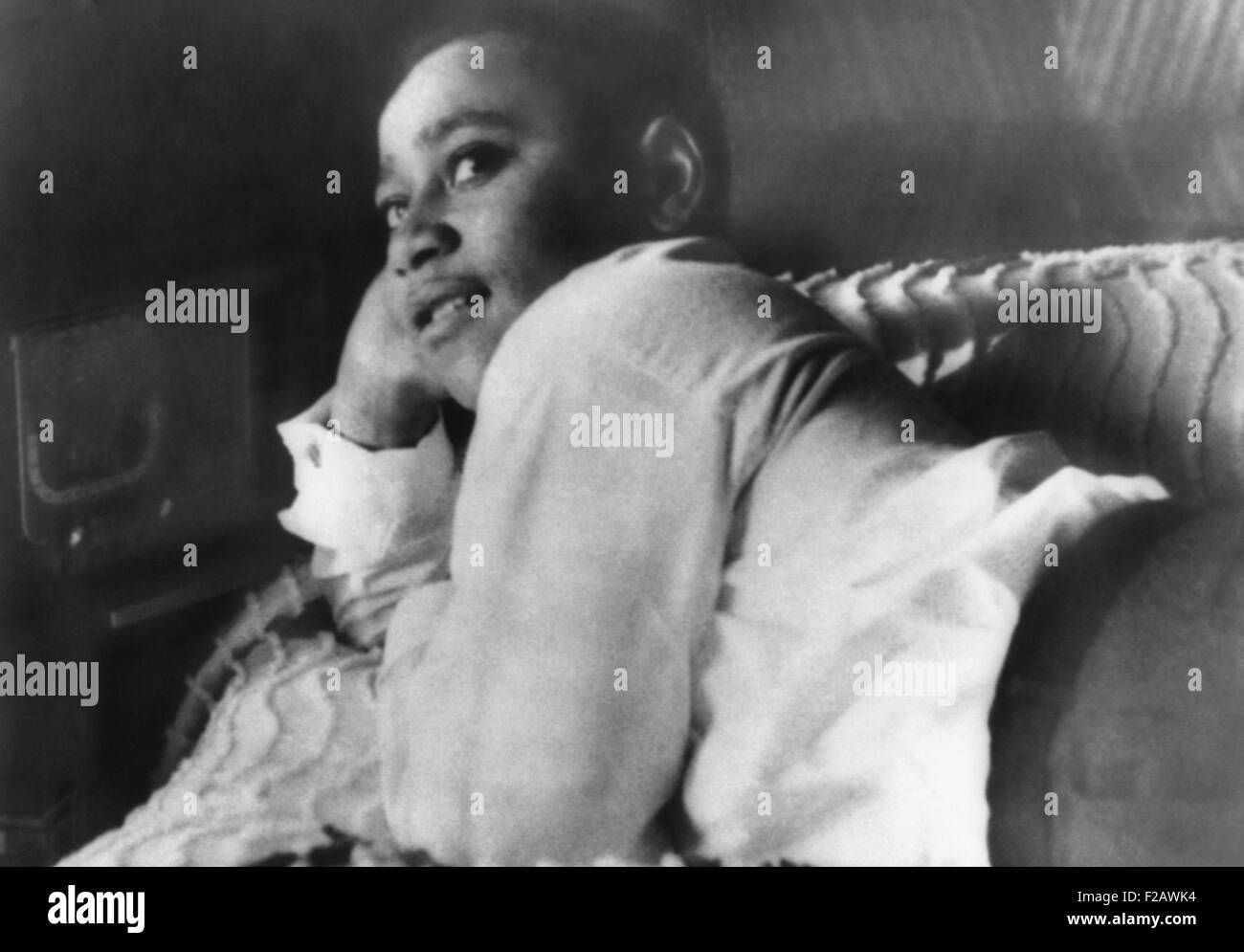 Emmett Till lying on his bed in his Chicago home in 1955. While visiting his relatives in Money, Mississippi, he spoke to 21-year-old white woman, Carolyn Bryant, the proprietor of a grocery store. Bryant's husband Roy and his half-brother J. W. Milam tortured and killed Emmett Till on Aug. 28, 1955. (CSU_2015_11_1334) Stock Photo