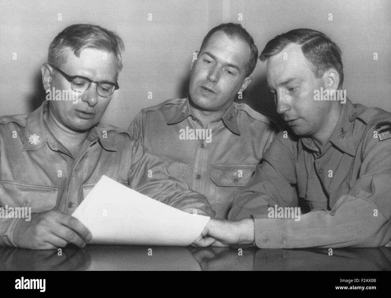 Major Roland E. Alley (center), a 14 year Army veteran, charged misconduct as a Korean War POW. August 22, 1955. His lawyer, Col. William T. Logan, warned that he was being singled out as a scapegoat while the Army was under pressure for being 'soft on Communism' by Joseph McCarthy. Convicted, he served 3.5 years in Leavenworth. In Sept. 1973, as a successful surveyor in Maine, he sought to have his case reviewed. (CSU 2015 11 1194) Stock Photo