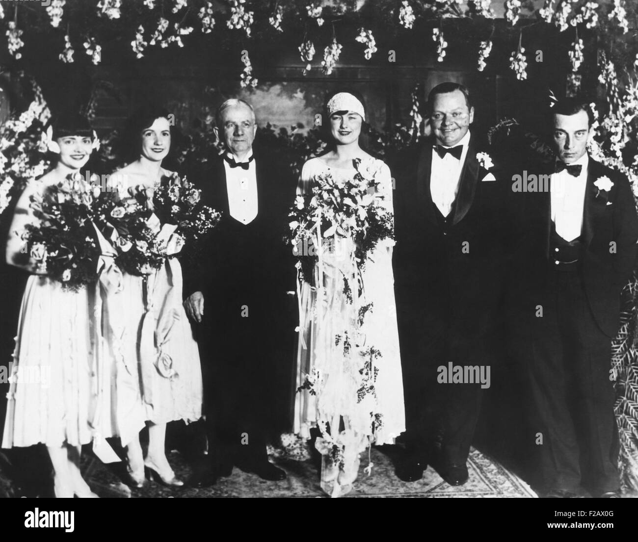Roscoe 'Fatty' Arbuckle and Doris Deane wedding on May 16, 1925. They were married at the home of the bride's mother in South Pasadena, California. L-R: Chrystine Francis, maid of honor; Natalie Talmadge Keaton, matron of honor; Judge Crawford; the bride; Arbuckle; and Buster Keaton best man. (CSU 2015 11 1190) Stock Photo