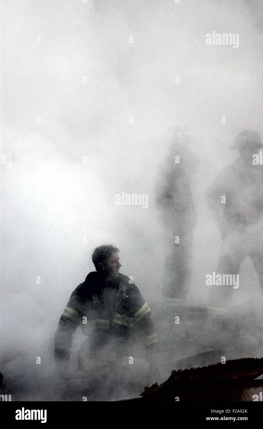 NYC Fireman emerges from the smoke and debris of the World Trade Center on Sept. 14, 2001. New York City, after September 11, 2001 terrorist attacks. U.S. Navy Photo by Jim Watson (BSLOC 2015 2 76) Stock Photo