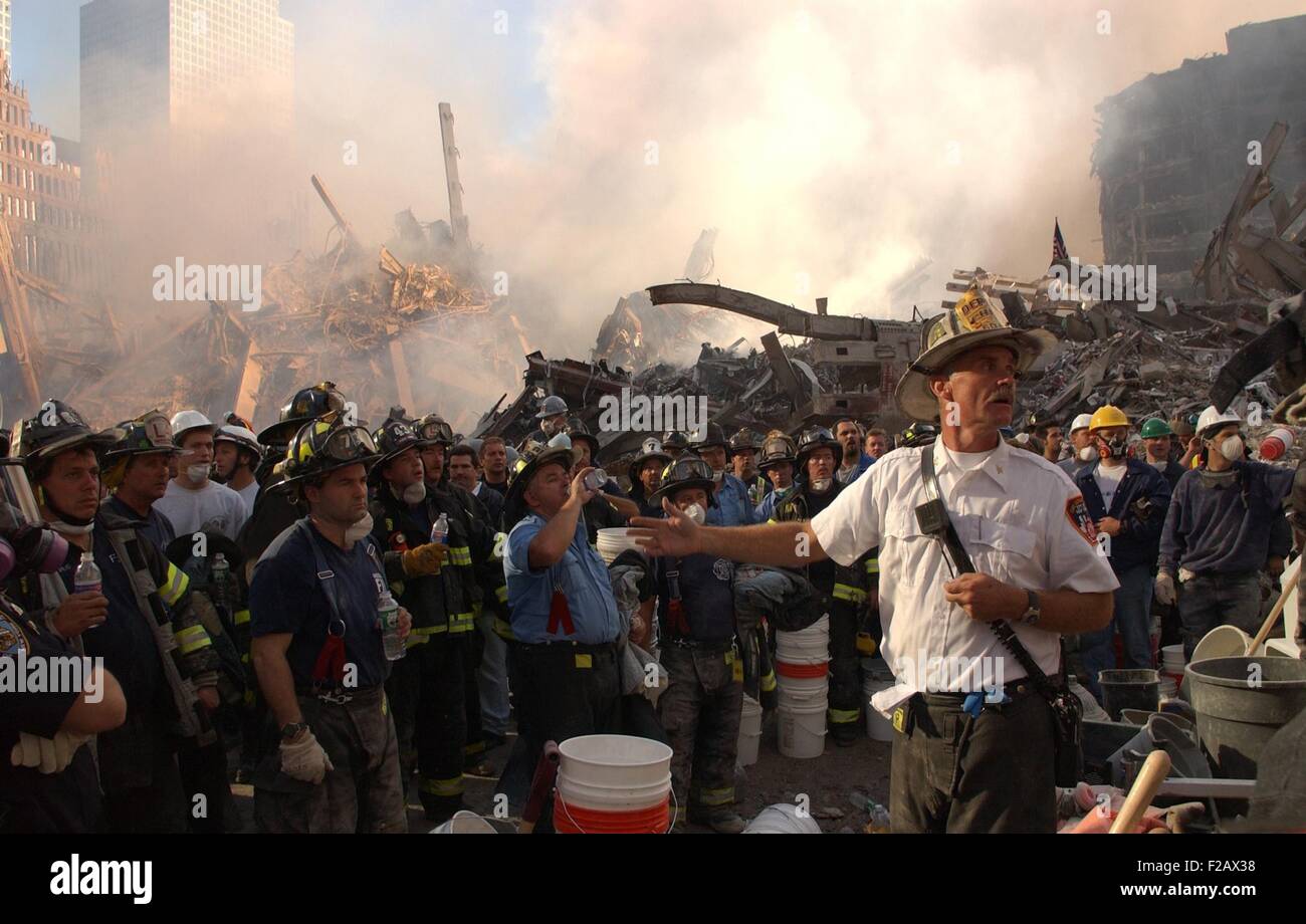 A NYC Fire Chief addresses firefighters at Ground Zero on Sept. 12, 2001. On the first day after 9-11, the firemen were concerned about the shifting of surrounding buildings at the 9-11 crash site. World Trade Center, New York City, after September 11, 2001 terrorist attacks. (BSLOC_2015_2_62) Stock Photo